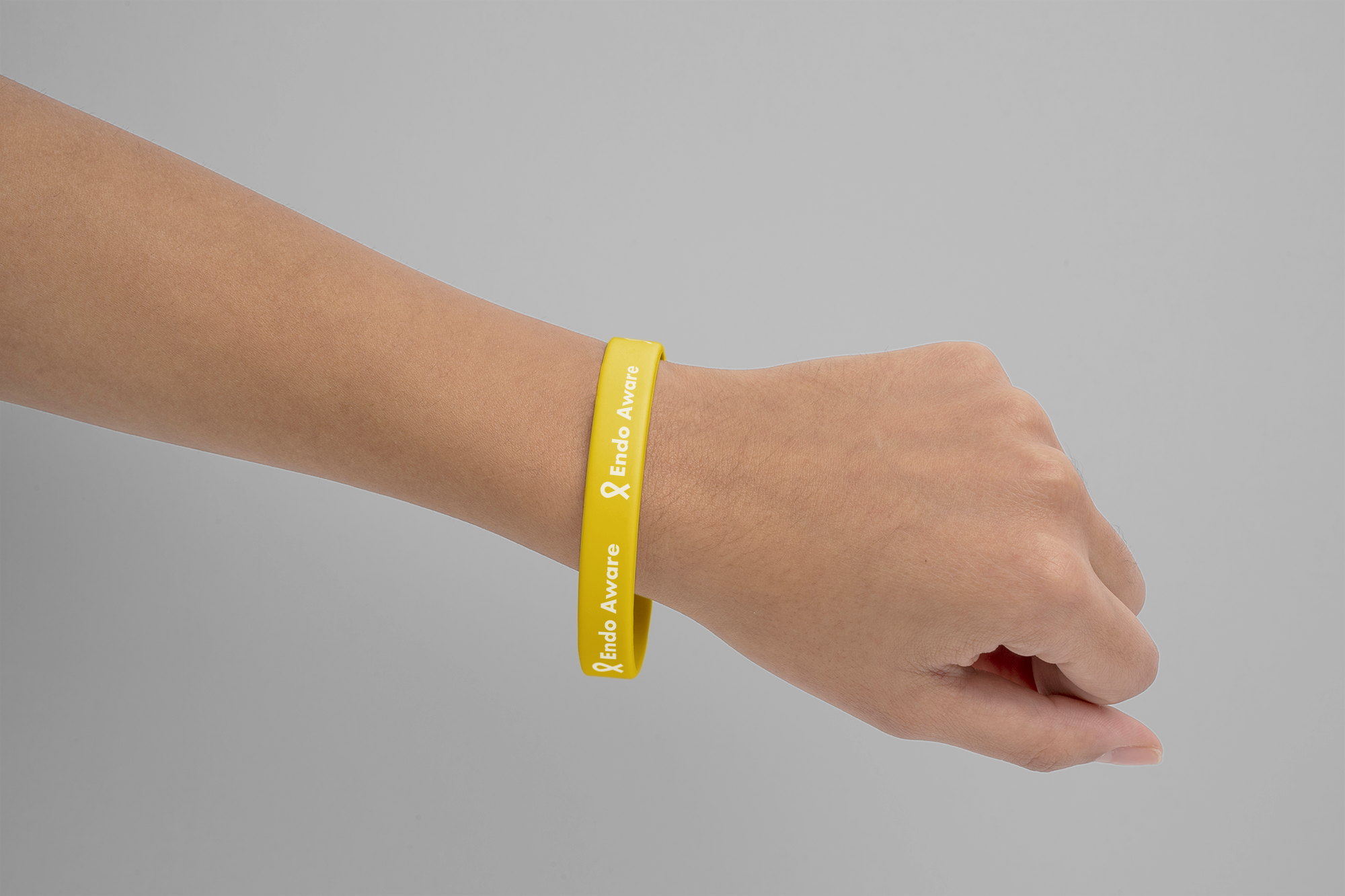 Yellow rubber wristband on wrist with EndoAware branding.